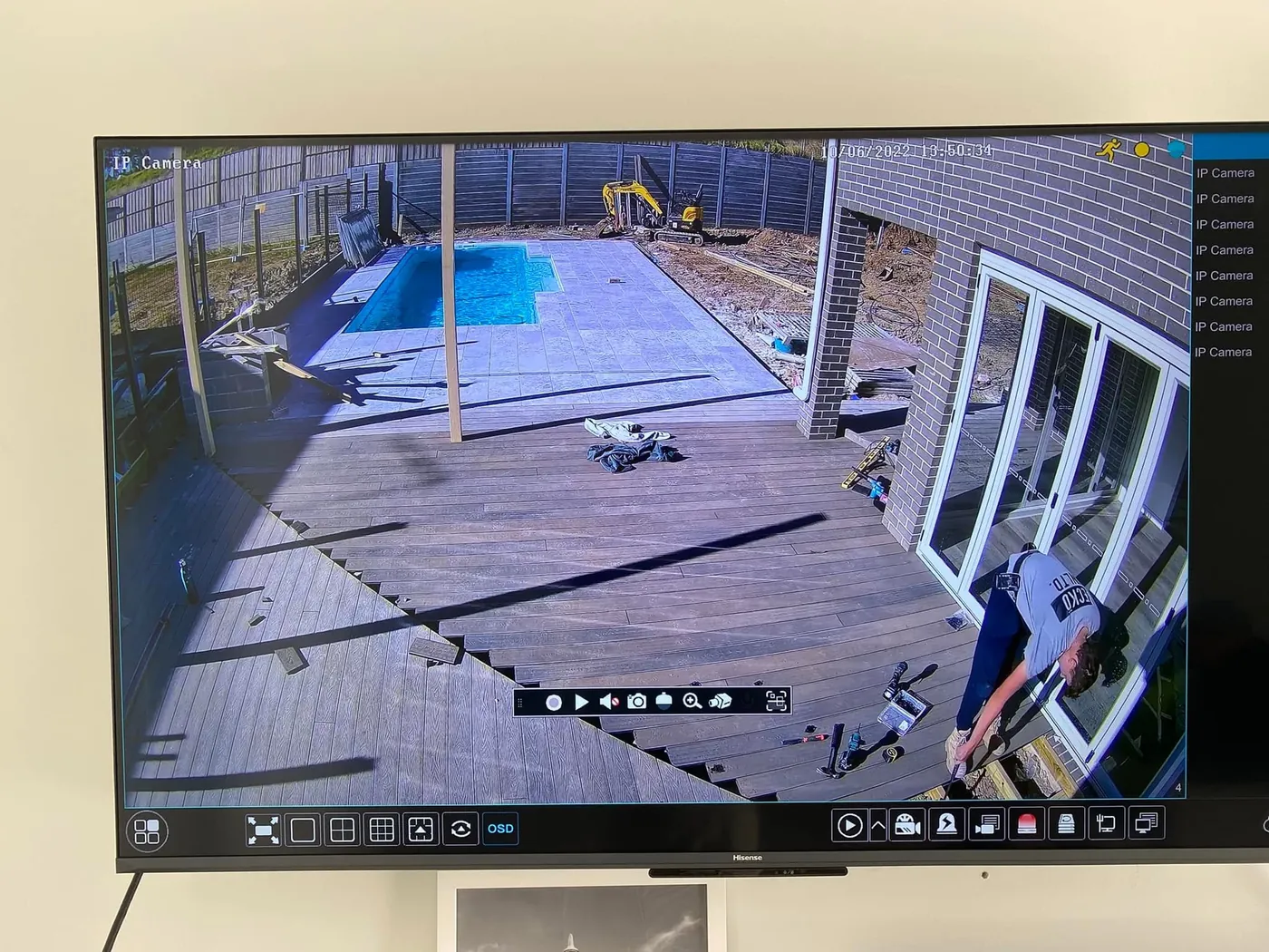 CCTV view of a backyard deck and pool on a TV