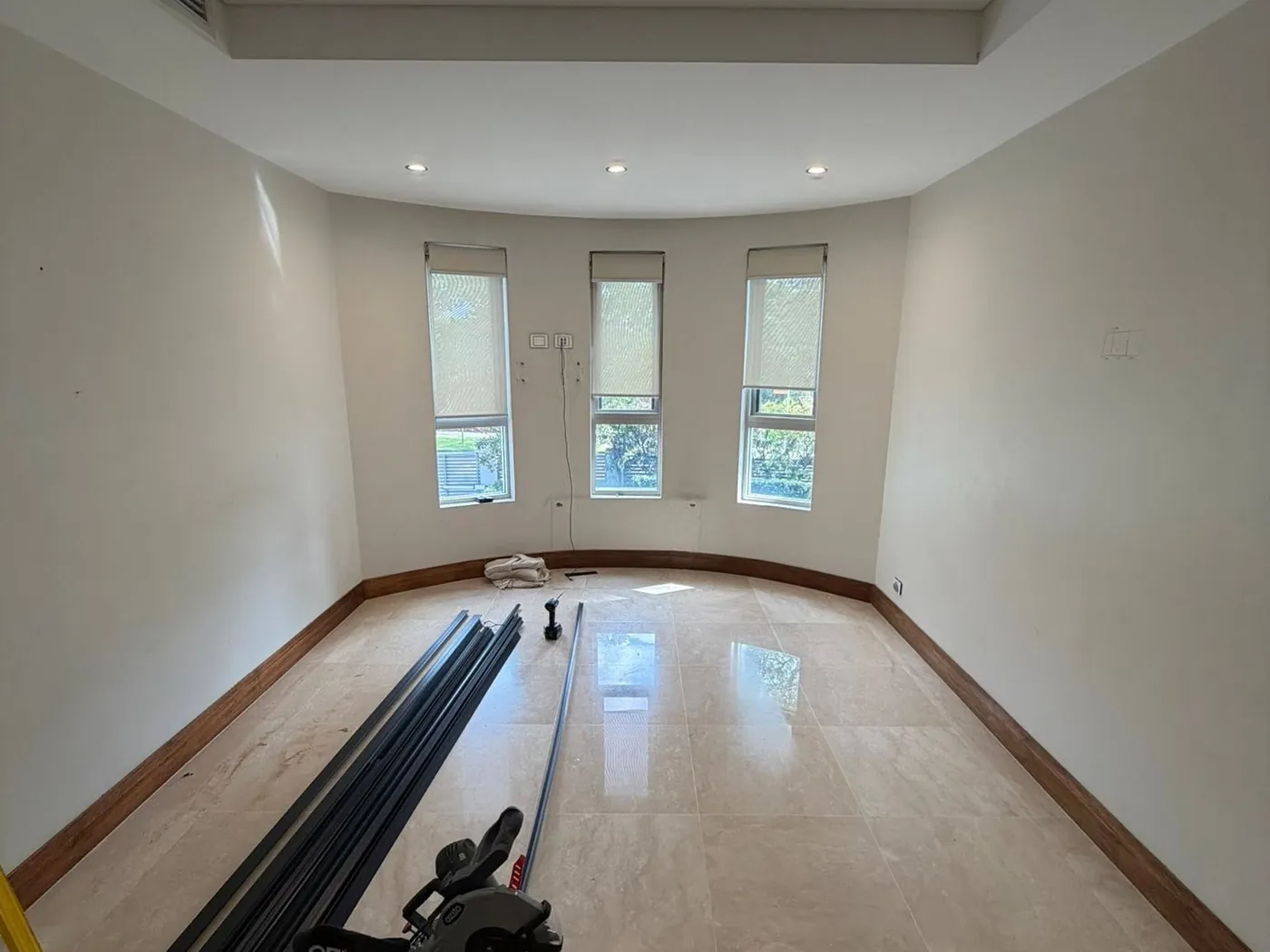 Empty room with a marble floor and three narrow windows, before the build