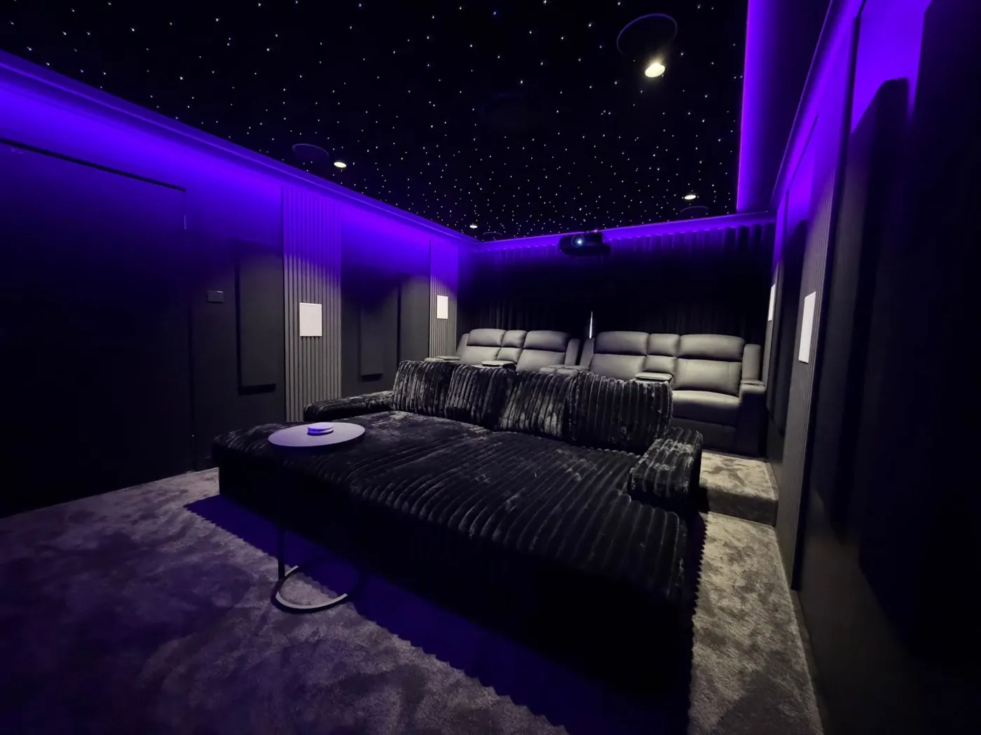 Finished cinema room with a star-light ceiling, purple LED lighting, a lounge bed and recliners