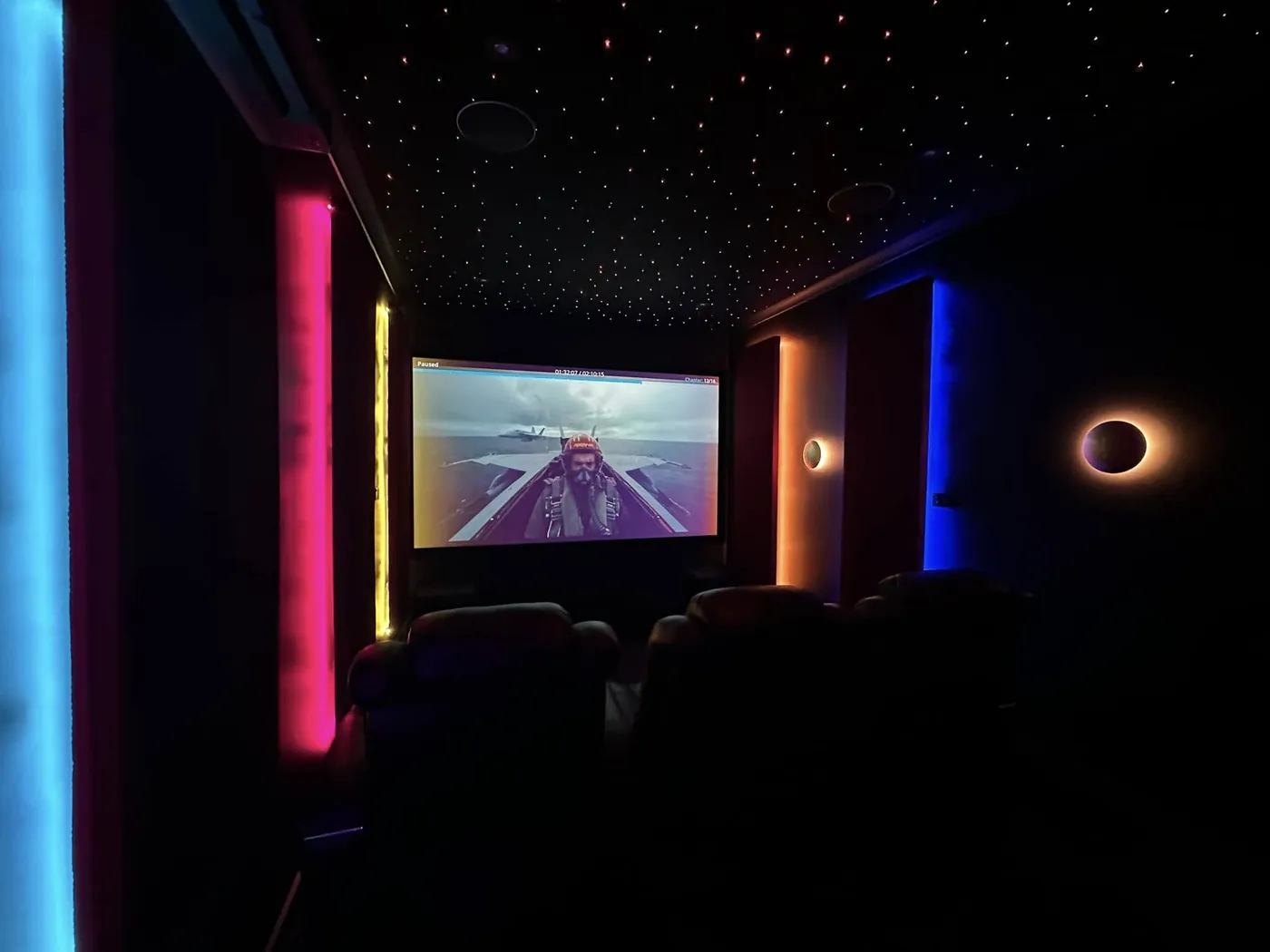 Coloured LED wall strips and a star-light ceiling in a cinema room