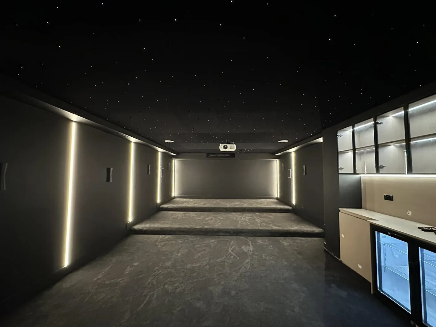 Vertical LED wall strips and a lit bar area in a cinema room