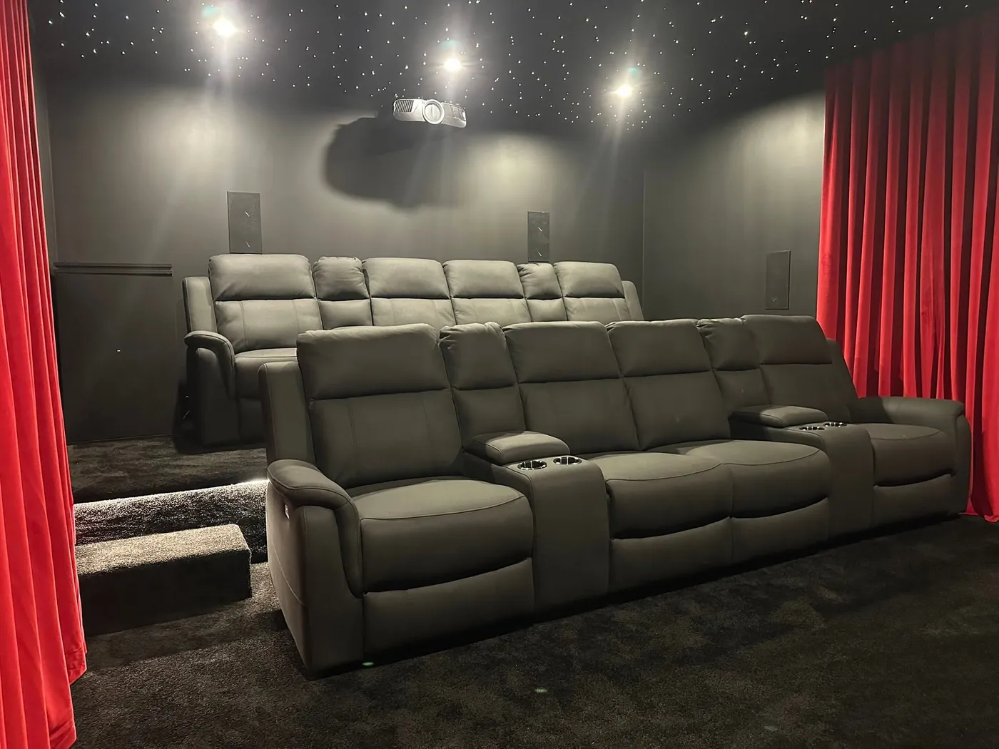 Two rows of grey leather recliners with the back row raised