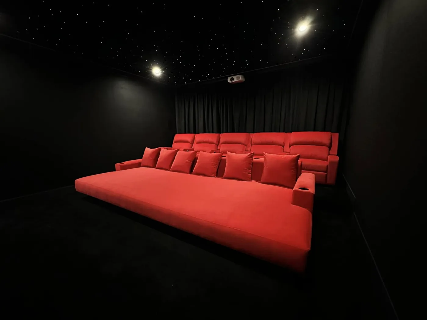 Red cinema lounge bed with matching recliners behind