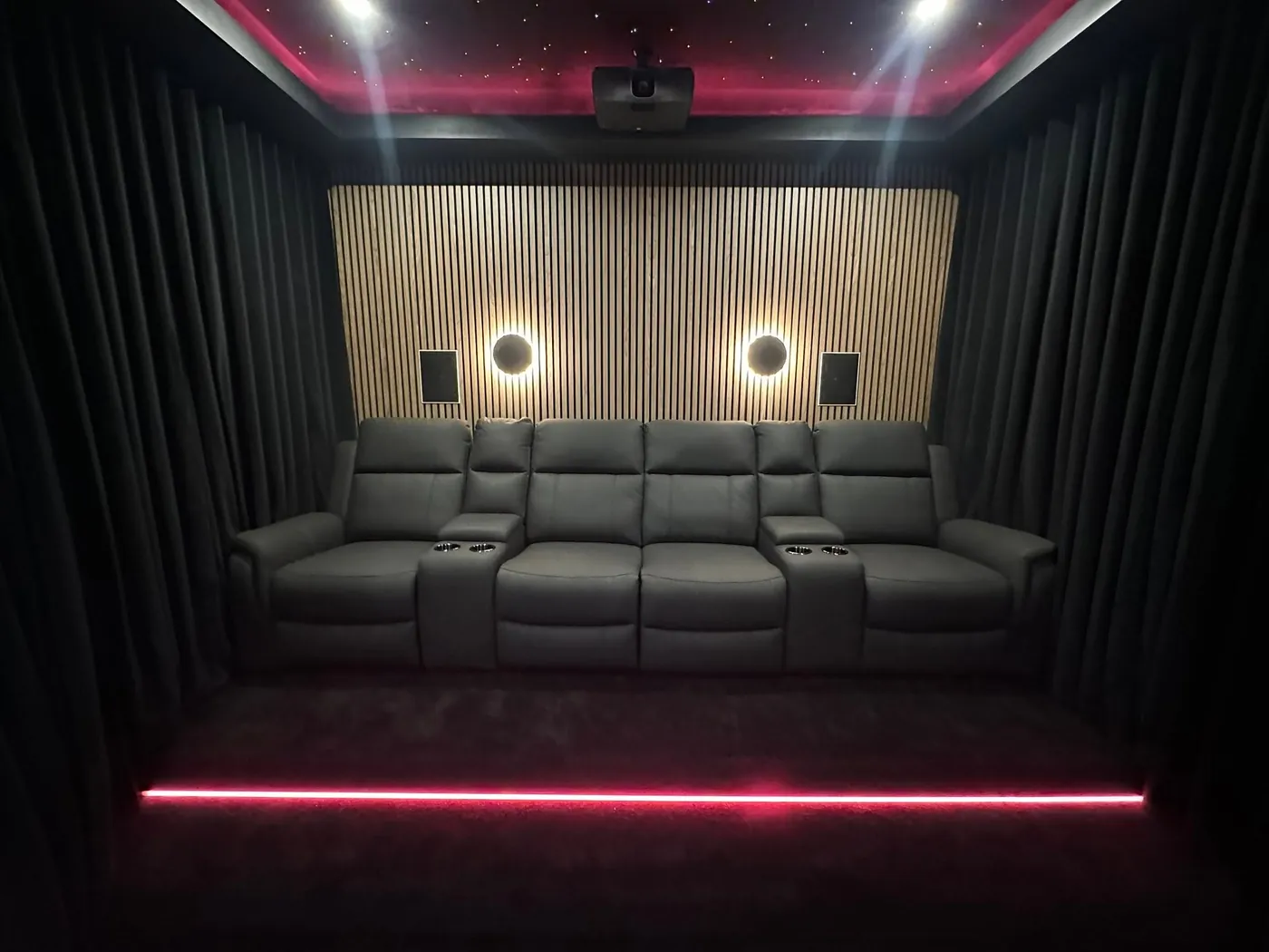 Row of black leather recliners with red step lighting