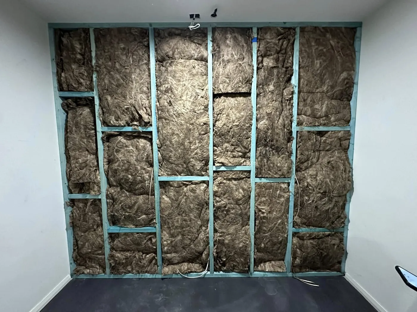 Wall framed out and packed with acoustic insulation batts before sheeting