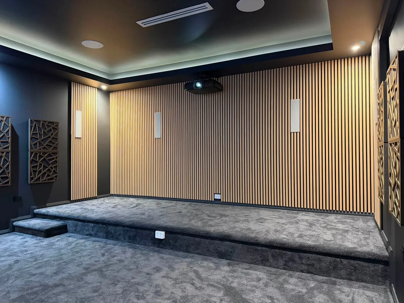 Timber slat acoustic wall behind a carpeted riser