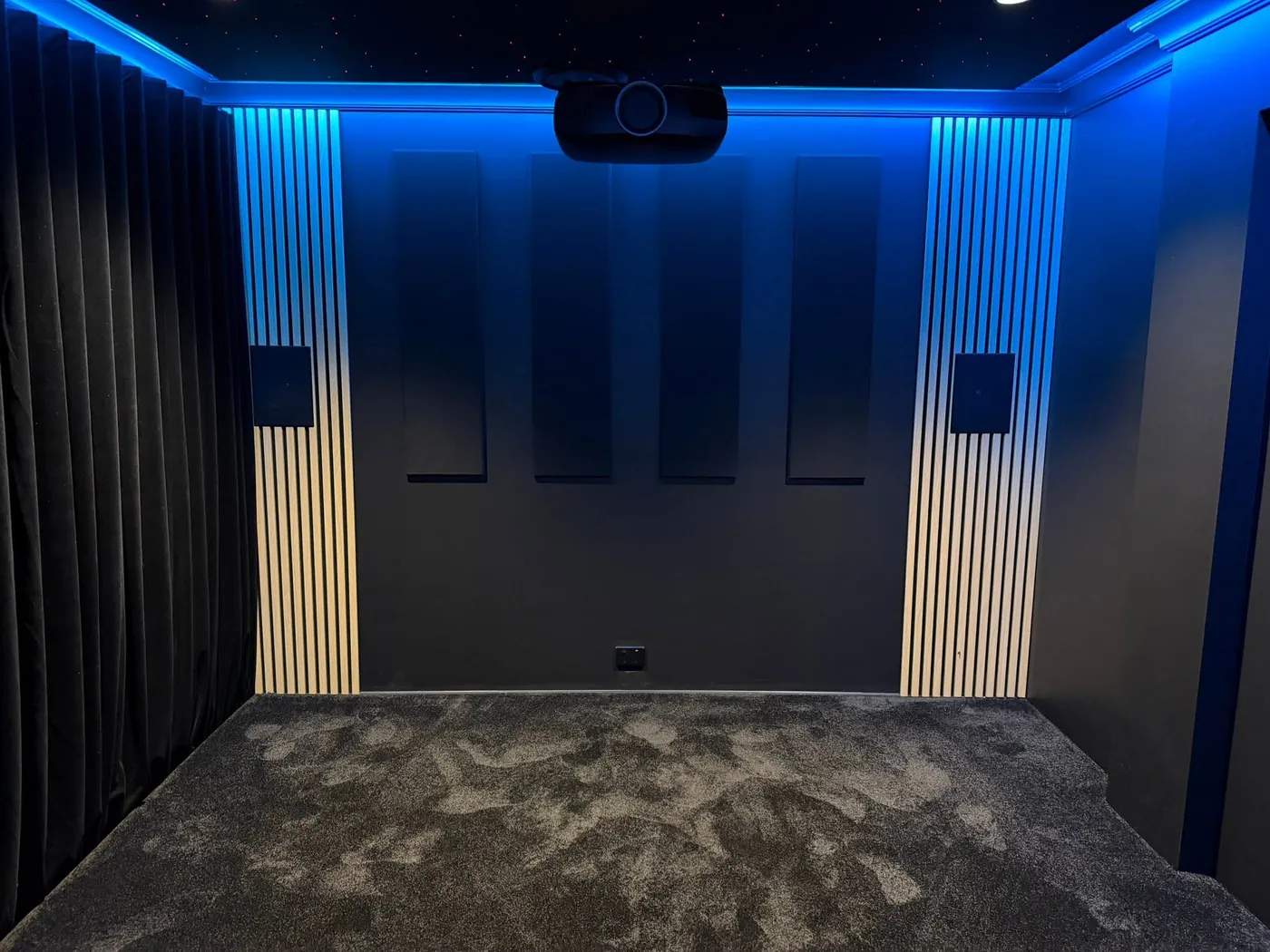 Acoustic panels between timber slat columns under blue LED lighting