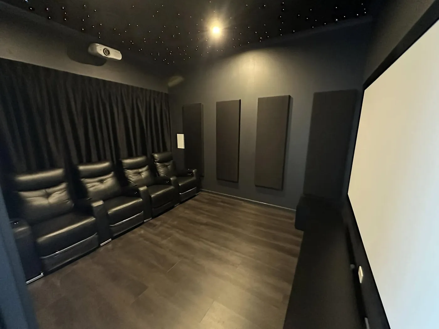 Cinema room with recliners, acoustic wall panels and a projection screen