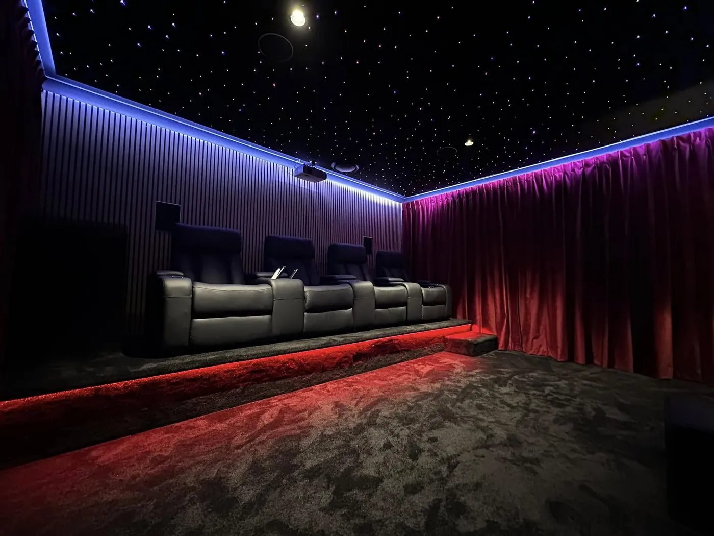 Star-light ceiling with blue and red LED lighting above a row of recliners